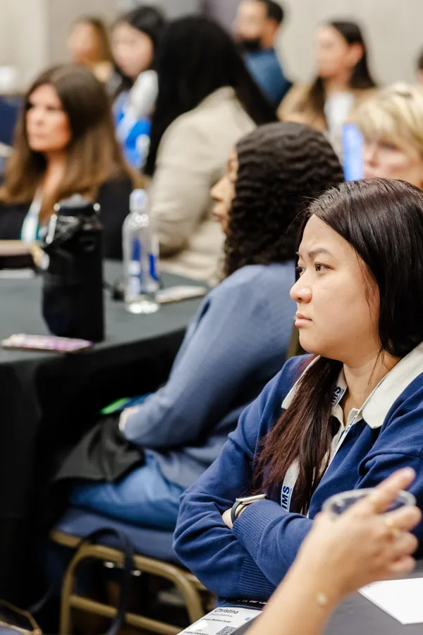 An attendee glances at her phone during a session.