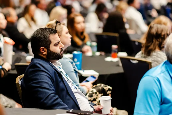 An attendee looks at his phone at a table during the conference.