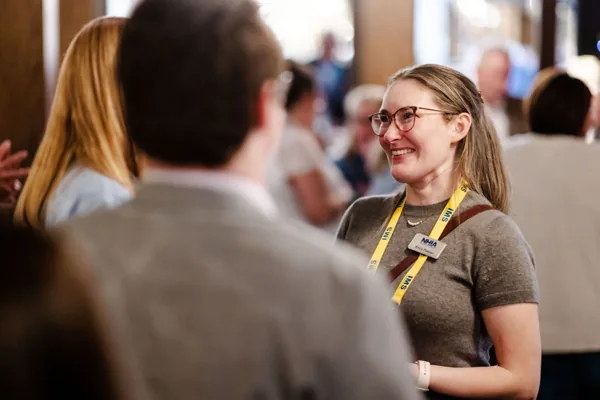 Two attendees lean in for a conversation during a break.